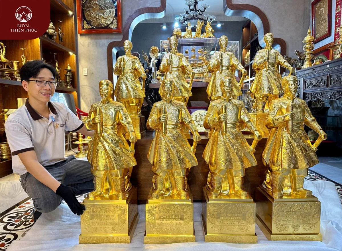 Trong phong thuỷ, tượng đồng Trần Hưng Đạo là biểu tượng phong thuỷ của văn hoá Việt Nam cũng như tượng Quan Công trong văn hoá Trung Hoa. Trần Hưng Đạo được tôn là Đức Thánh Trần hay Quan Vân Trường được tôn là Quan Thánh. tượng Hưng Đạo vương cũng rất có hiệu quả trong việc trấn trạch, xua đuổi tà ma và những vận khí xấu. Khi bài trí tượng Hưng Đạo vương, gia đình sẽ gặp nhiều thuận lợi về mặt đất cát, gia trạch, tránh được các vận xấu hoặc bệnh tật và tà ma quấy nhiễu gia đình. Hơn nữa, bài trí tượng đồng Hưng Đạo đại vương còn mang đến sự may mắn về đường công danh sự nghiệp, và tài lộc phú quý cho người chủ. Ý nghĩa này cũng là xuất phát từ việc Hưng Đạo vương khi còn sinh thời vẫn luôn nổi danh về tài trí và mưu dũng, công danh sự nghiệp luôn vững chắc và thăng tiến, người đời ai cũng nể phục, chứ không đem lòng ghen ghét, đố kỵ. Tượng Trần Hưng Đạo cũng được nhiều khách hàng sử dụng làm quà tặng đối tác, giúp cho không gian làm việc trở nên bắt mắt và giúp thăng tiến. Đồ đồng Thiên Phúc với sự cố gắng vươn lên và đã có những công trình tiêu biểu và được rất nhiều khách hàng quan tâm bởi sự chỉn chu và tinh xảo của sản phẩm khách hàng đặt. Được sự tin tưởng của quý khách hàng, Đồ đồng Thiên Phúc đã chế tác và hoàn thiện sản phẩm theo yêu cầu. Với những đường nét tinh xảo, tỉ mỉ của người nghệ nhân dày dặn kinh nghiệm đã đưa tới khách hàng sản phẩm sinh động và sắc nét. Đồ đồng Thiên Phúc chân thành cảm ơn vị khách đã tin tưởng và ủng hộ tại cửa hàng Thiên Phúc. Chúng tôi luôn cam kết sẽ mang tới những sản phẩm tốt nhất tới tay người tiêu dùng. Đồ đồng Thiên Phúc được sự tin tưởng của khách hàng chúng tôi sẽ ngày càng cố gắng vươn mình phát triển ngành đồ đồng. Cảm ơn quý khách hàng đã luôn đồng hành cùng Đồ đồng Thiên Phúc chúng tôi. Chúc Quý gia chủ luôn mạnh khoẻ phát đạt và thành công. Quý khách hàng đang muốn tìm hiểu thêm về các mẫu quà tặng bằng đồng hãy liên hệ ngay tới hotline của chúng tôi để được tư vấn và hỗ trợ ngay hôm nay.